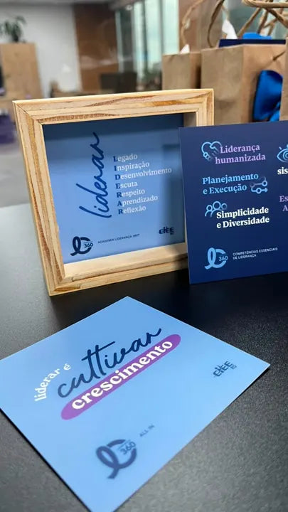 Quadro com cards de liderança sobre uma mesa de escritório